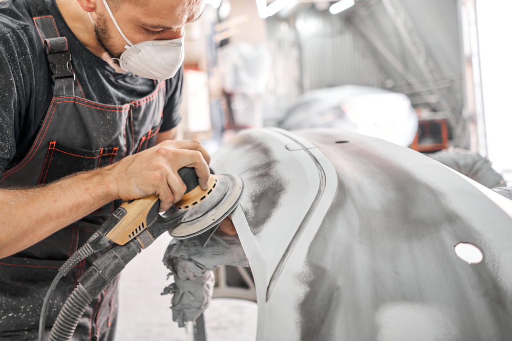 The,Mechanic,Works,With,A,Grinding,Tool.,Sanding,Of,Car